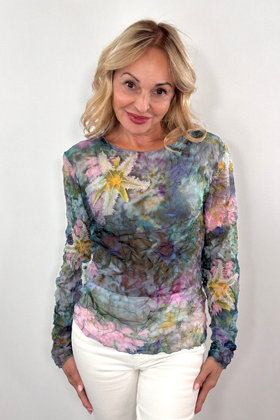 woman wearing a colorful floral long-sleeve sheer top