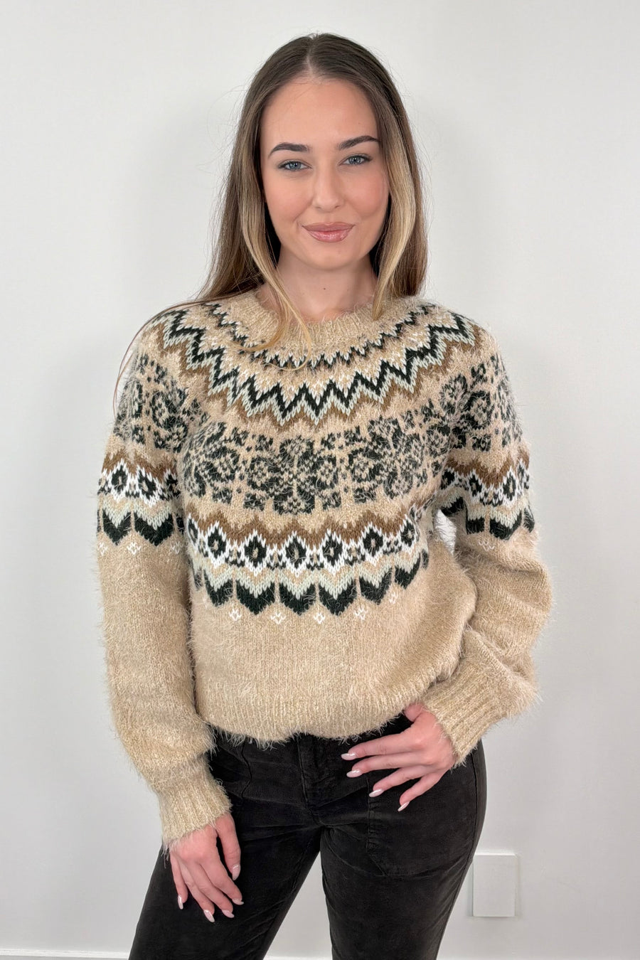 Woman wearing a patterned sweater against a white background