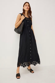 Woman wearing a black button up dress with embroidery detail