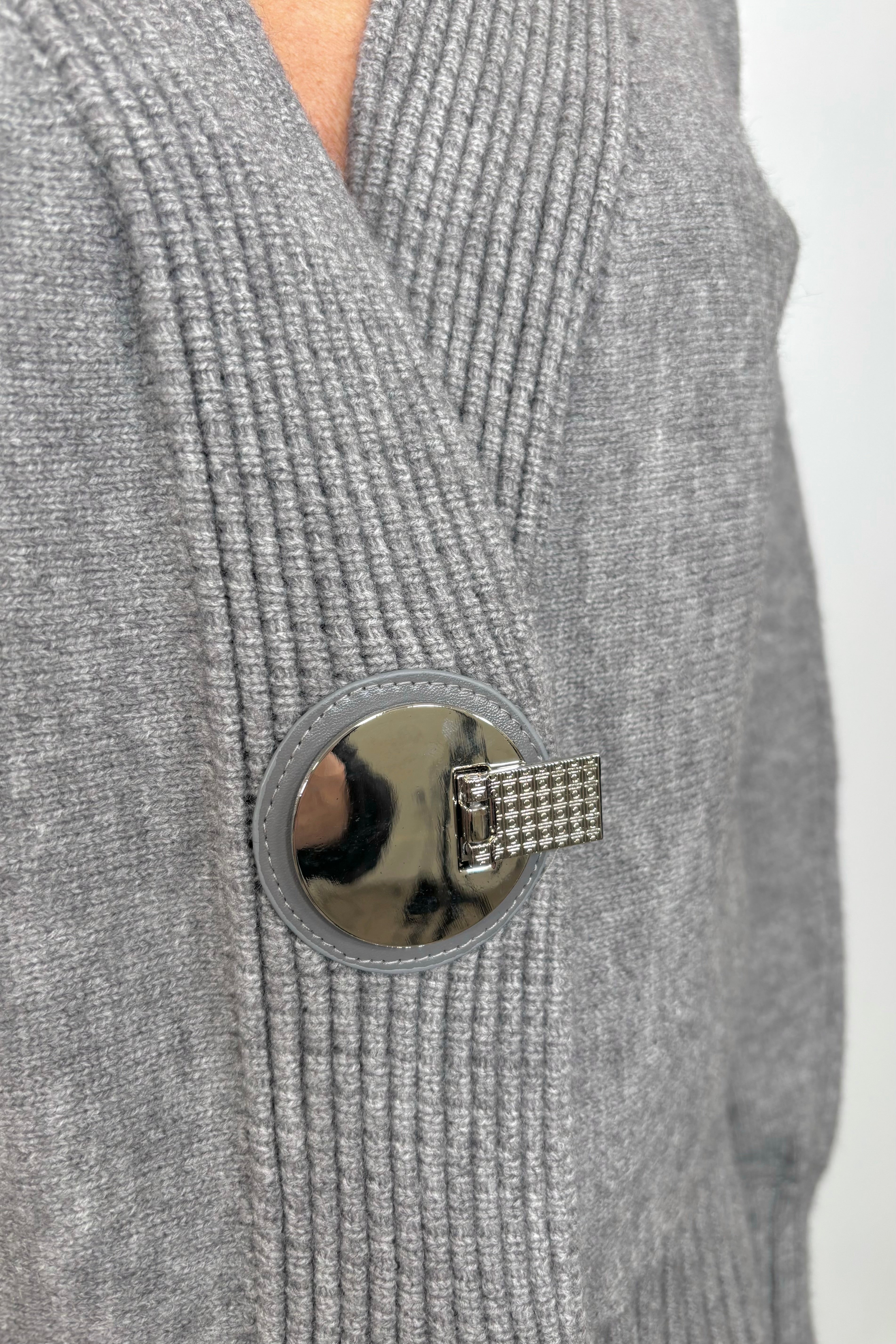 Close up view of the silver hardware of gray cardigan