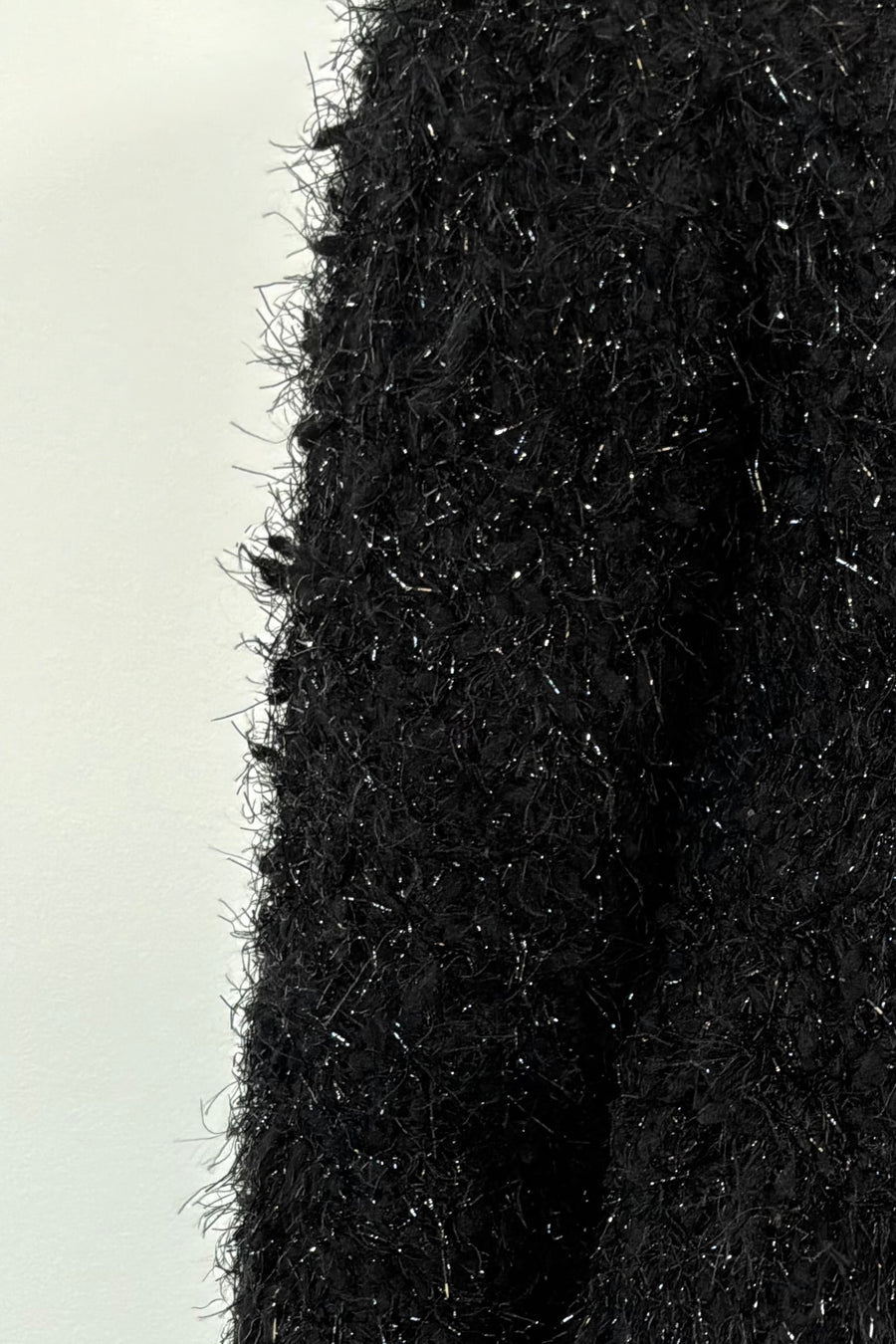 Close-up of black textured cardigan