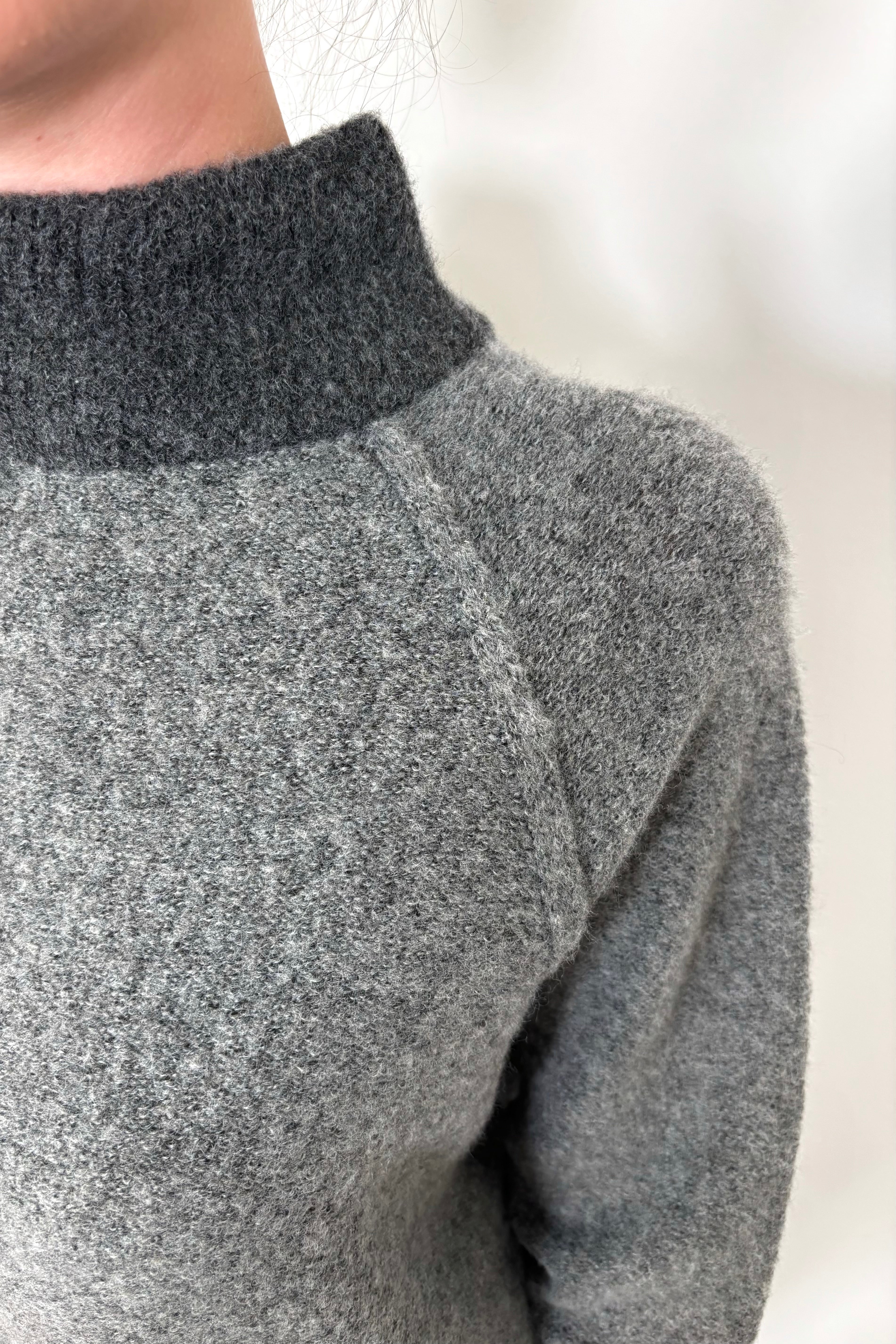 close up of woman wearing two toned gray sweater