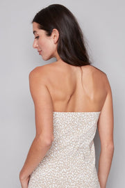 Woman wearing a strapless white and beige leopard print top