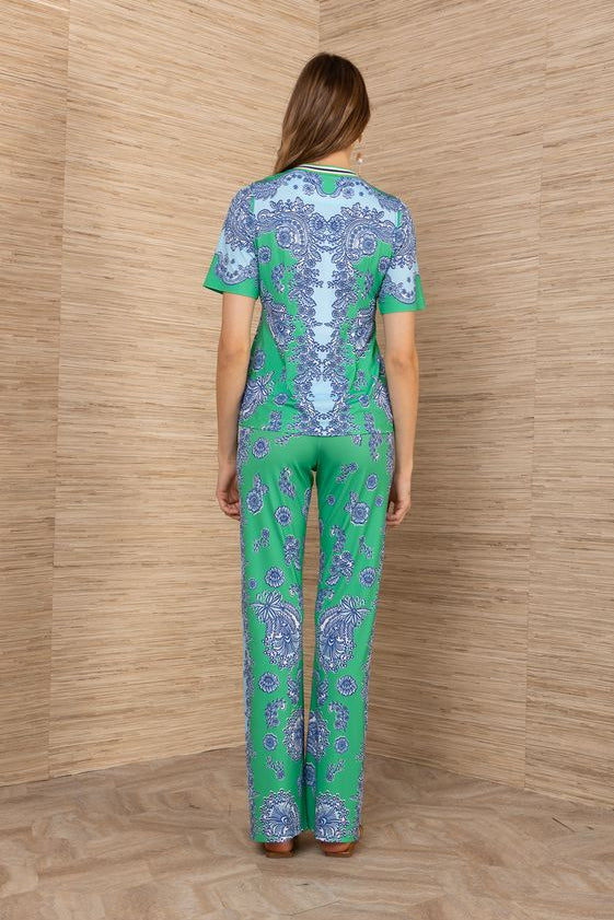 back facing woman wearing a silk green and blue patterned tee