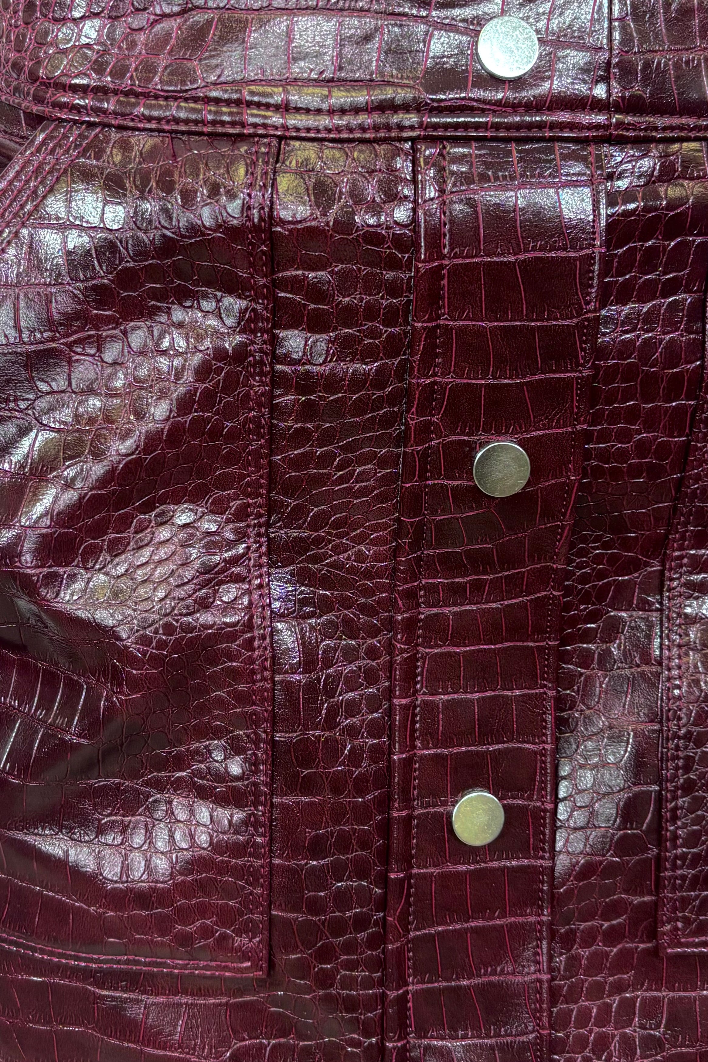 Close-up of a short burgundy button front Russi leather skirt
