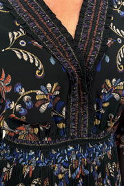 close up view of woman wearing a black v-neck maxi dress with a colourful pattern