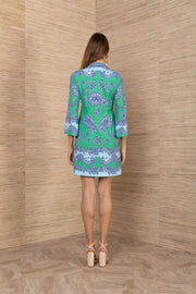 Woman wearing a blue and green patterned short dress with a 3/4 sleeves