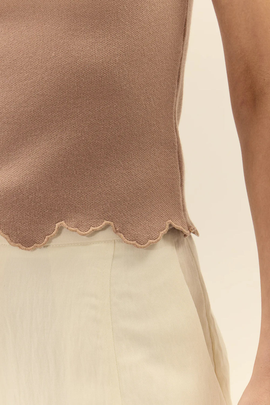 close up of a woman wearing a brown knit sleeveless top