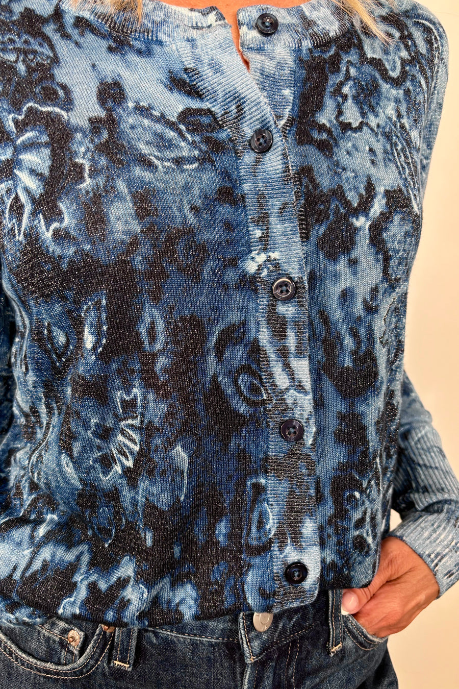 Zoom in view of woman wearing a blue patterned thin cardigan