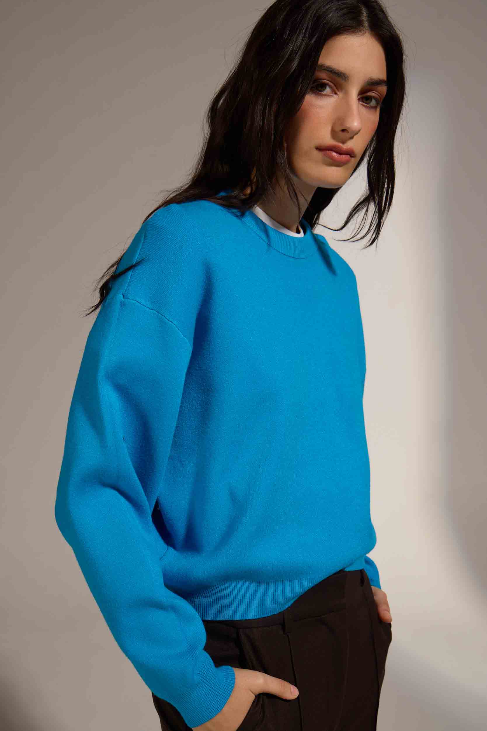 Person wearing a bright blue sweater against a neutral background