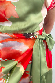 Woman wearing a boat neck short sleeve wrap waist scarf colorful floral dress