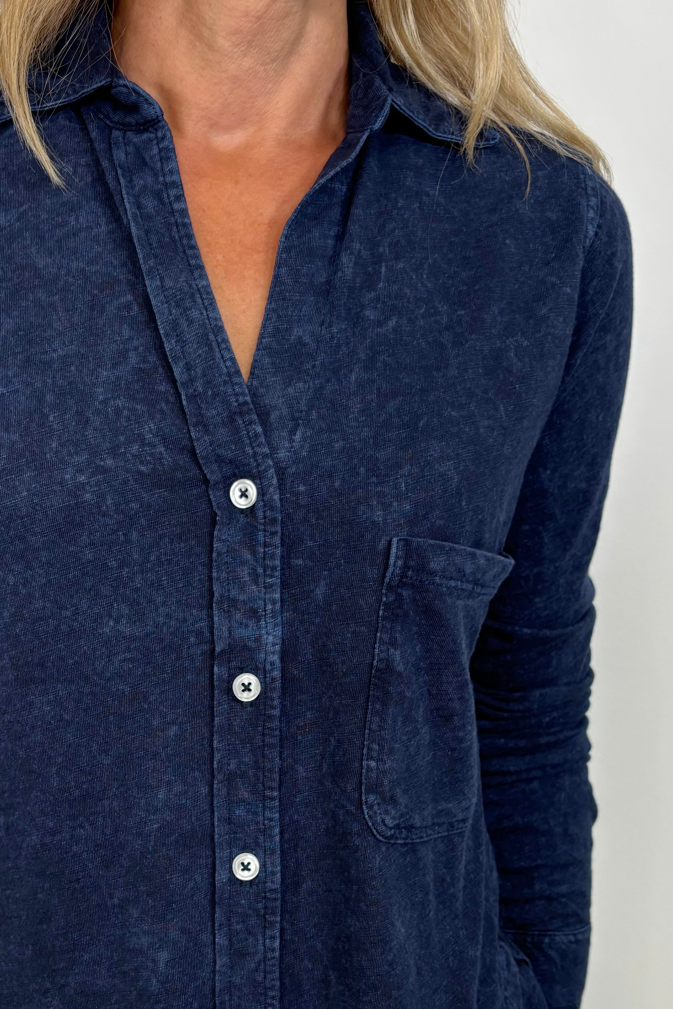 Close-up of the neckline of a washed blue button down shirt