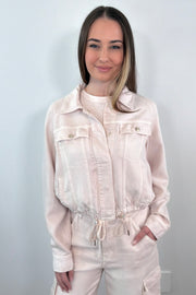 woman wearing a buttoned up light pink denim jacket 