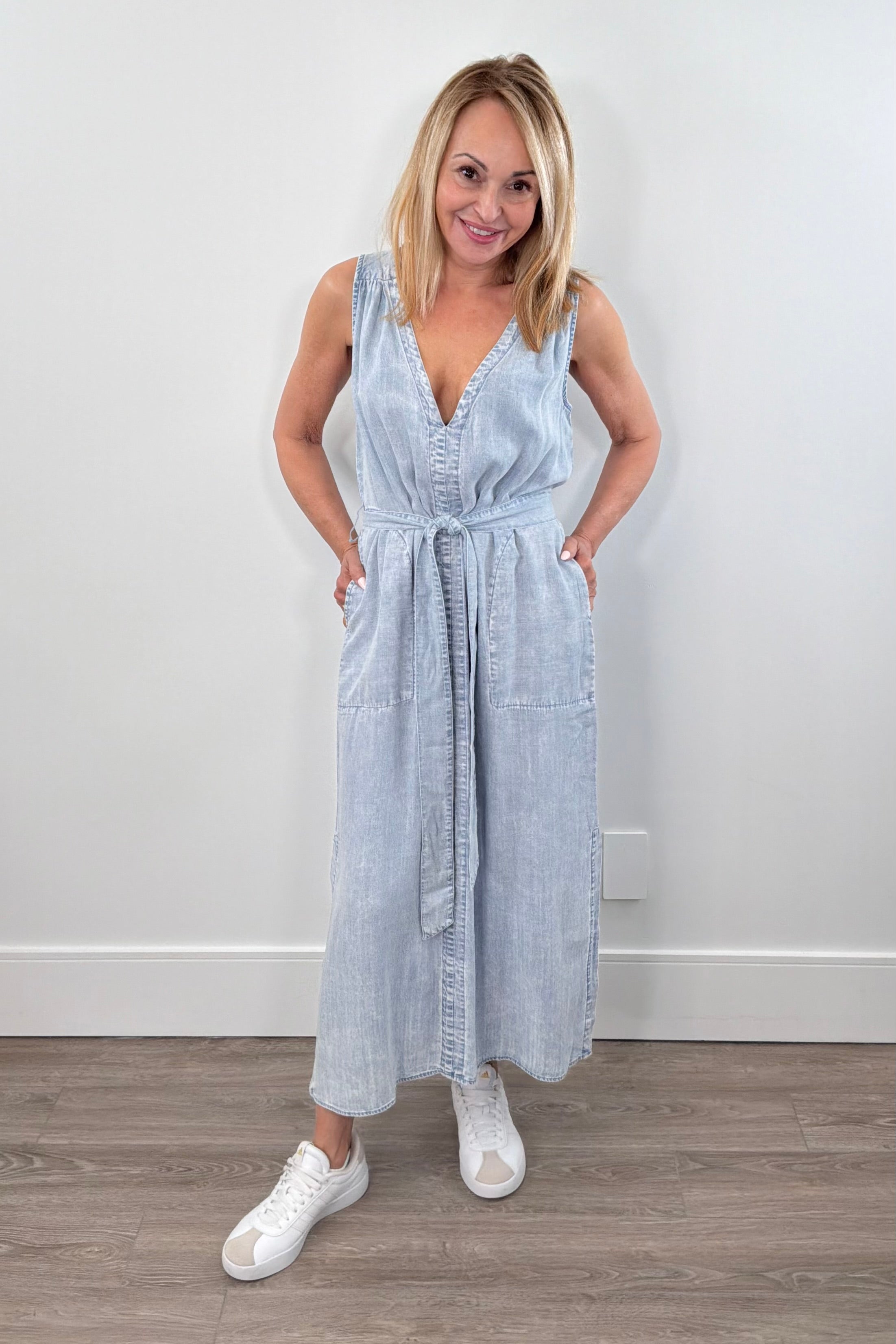 Light wash sleeveless denim midi dress with a V-neck and tie waist, front view