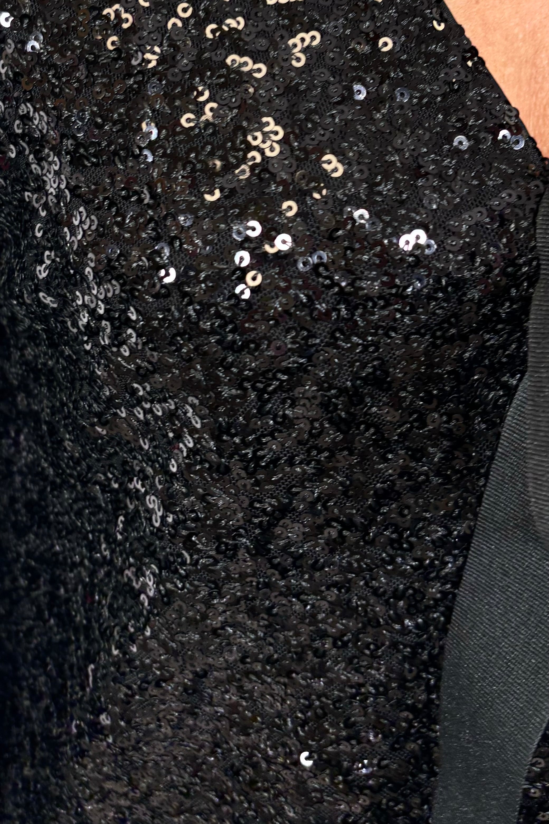 Close-up of a black sequinned tie front cardigan
