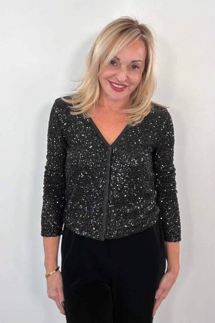 Woman wearing a snap on black sequin cardigan