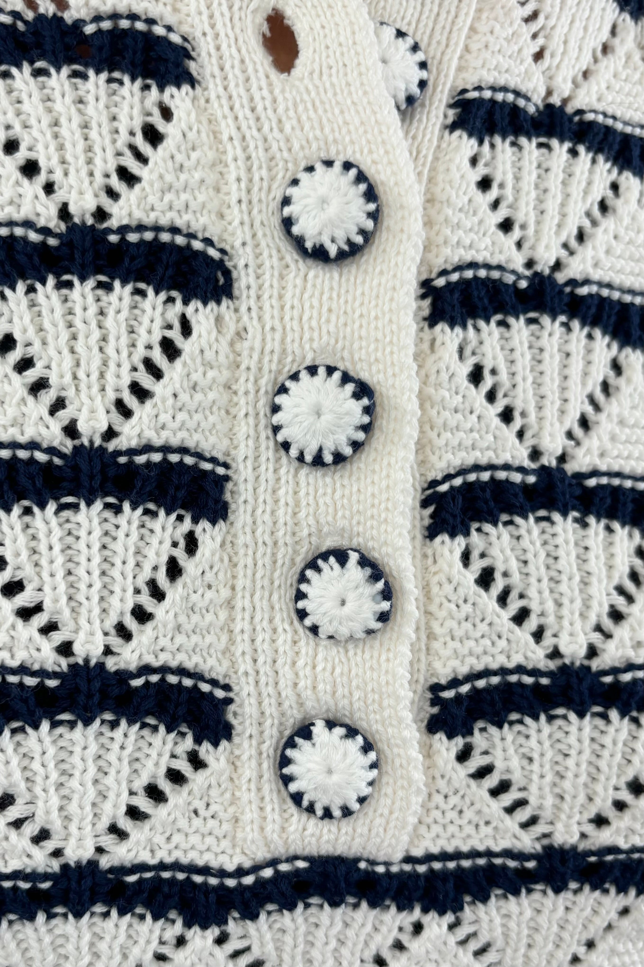 Close up of Woman wearing a black and white striped knitted short sleeve Henley tee