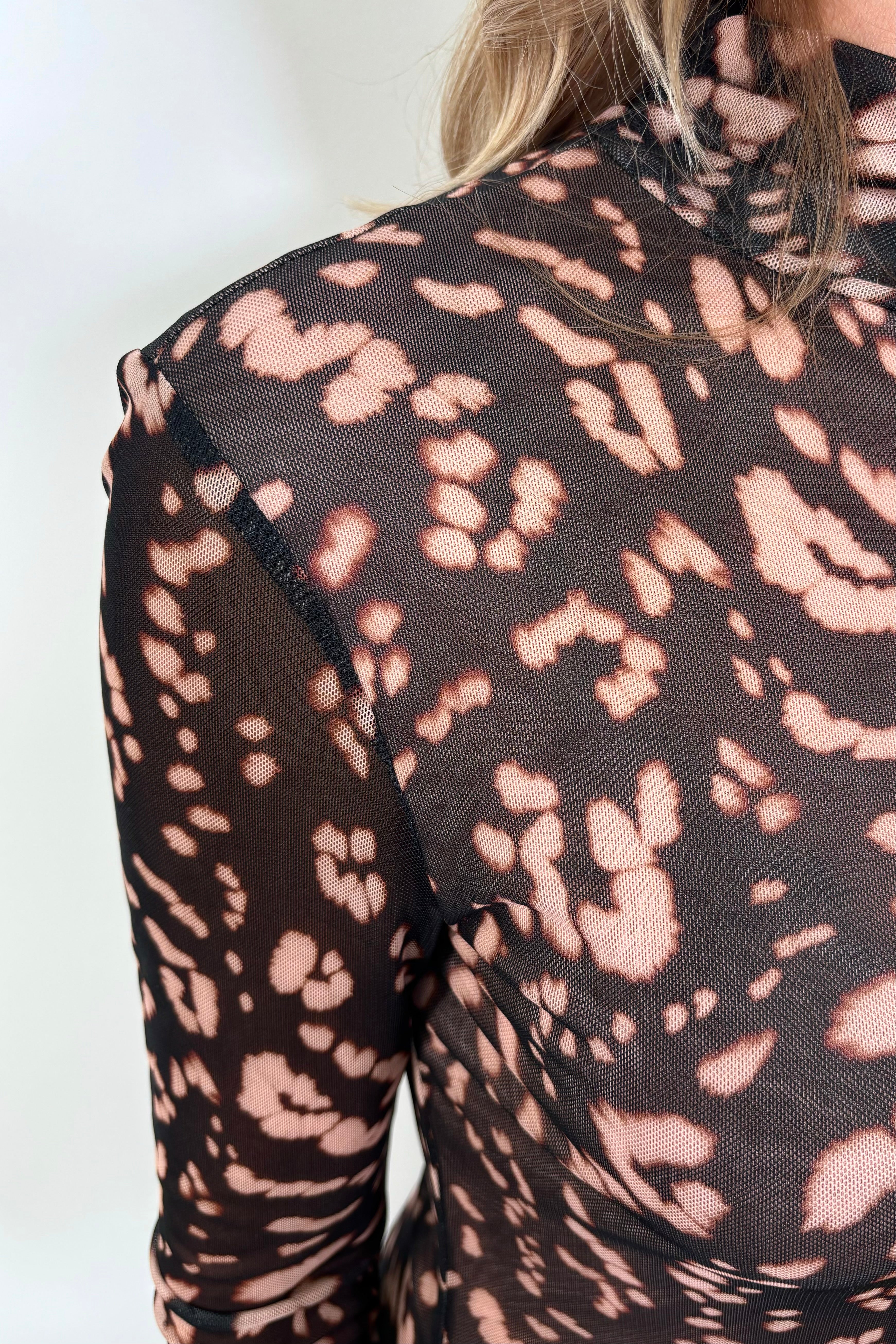 close-up of the neck of a leopard print mesh dress