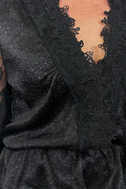 close-up of the lace detailing on the neckline of a black top