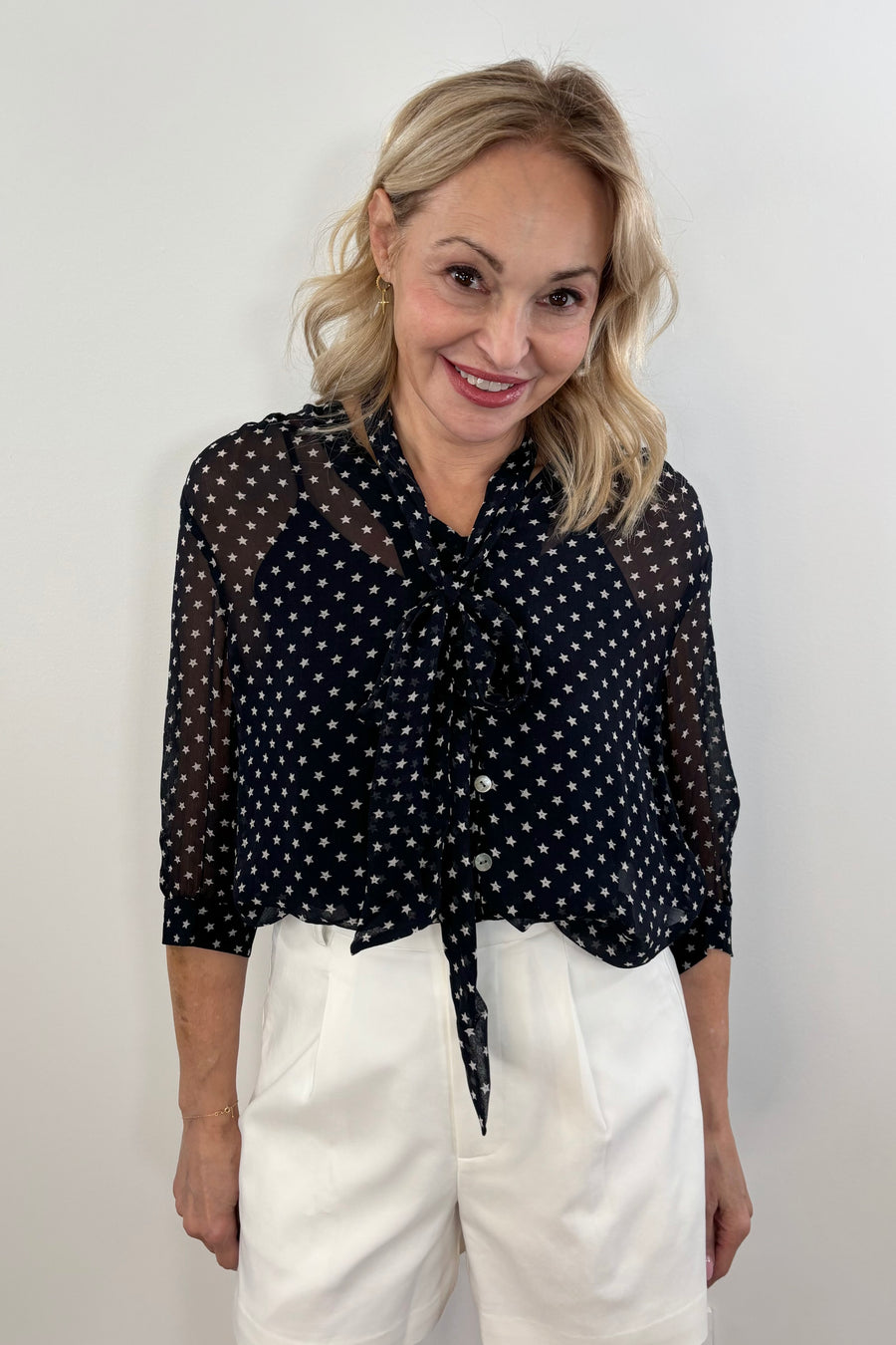 Woman wearing a navy blouse with white star print allover