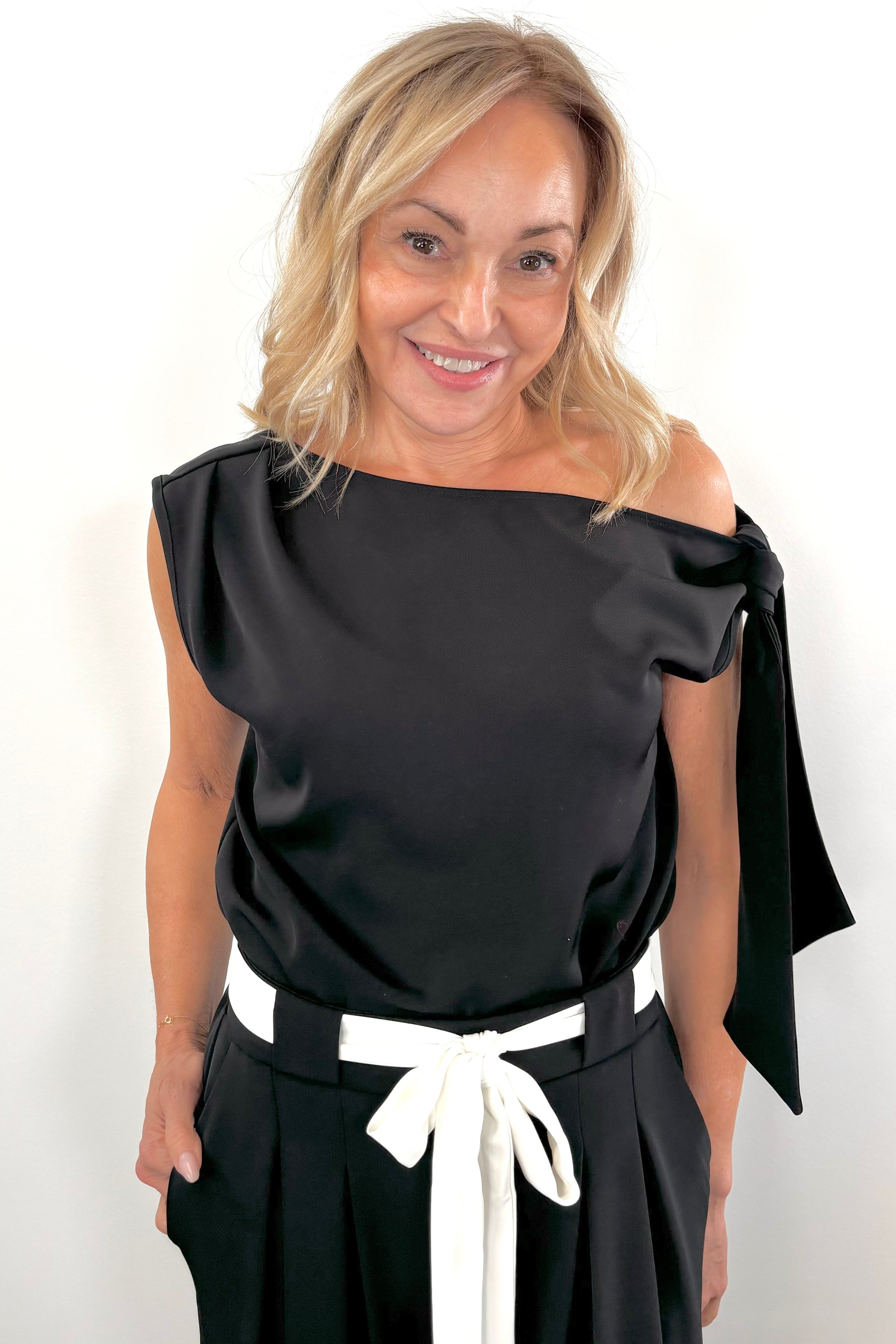 Woman wearing a wide neckline off the shoulder top in black