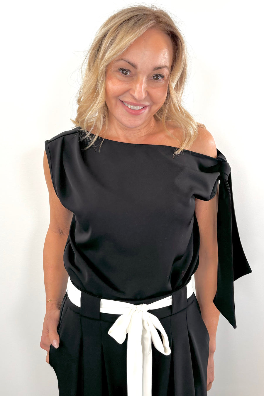Woman wearing a wide neckline off the shoulder top in black