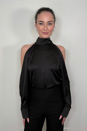 Front view of woman wearing a black satin off-shoulder halter top 