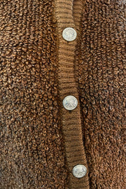 Close-up of a brown textured fabric with silver buttons