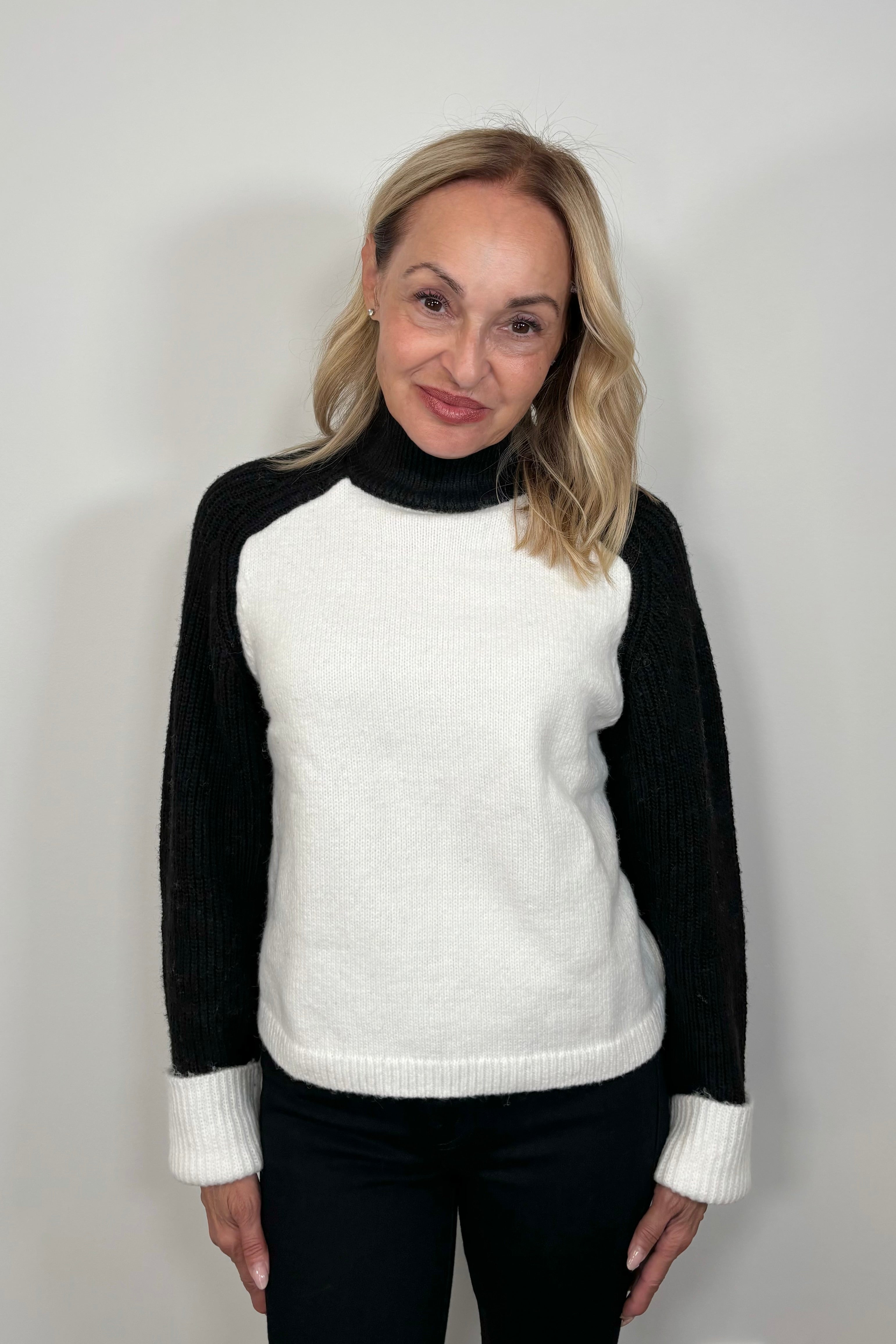 Front view of a woman wearing a black and white sweater