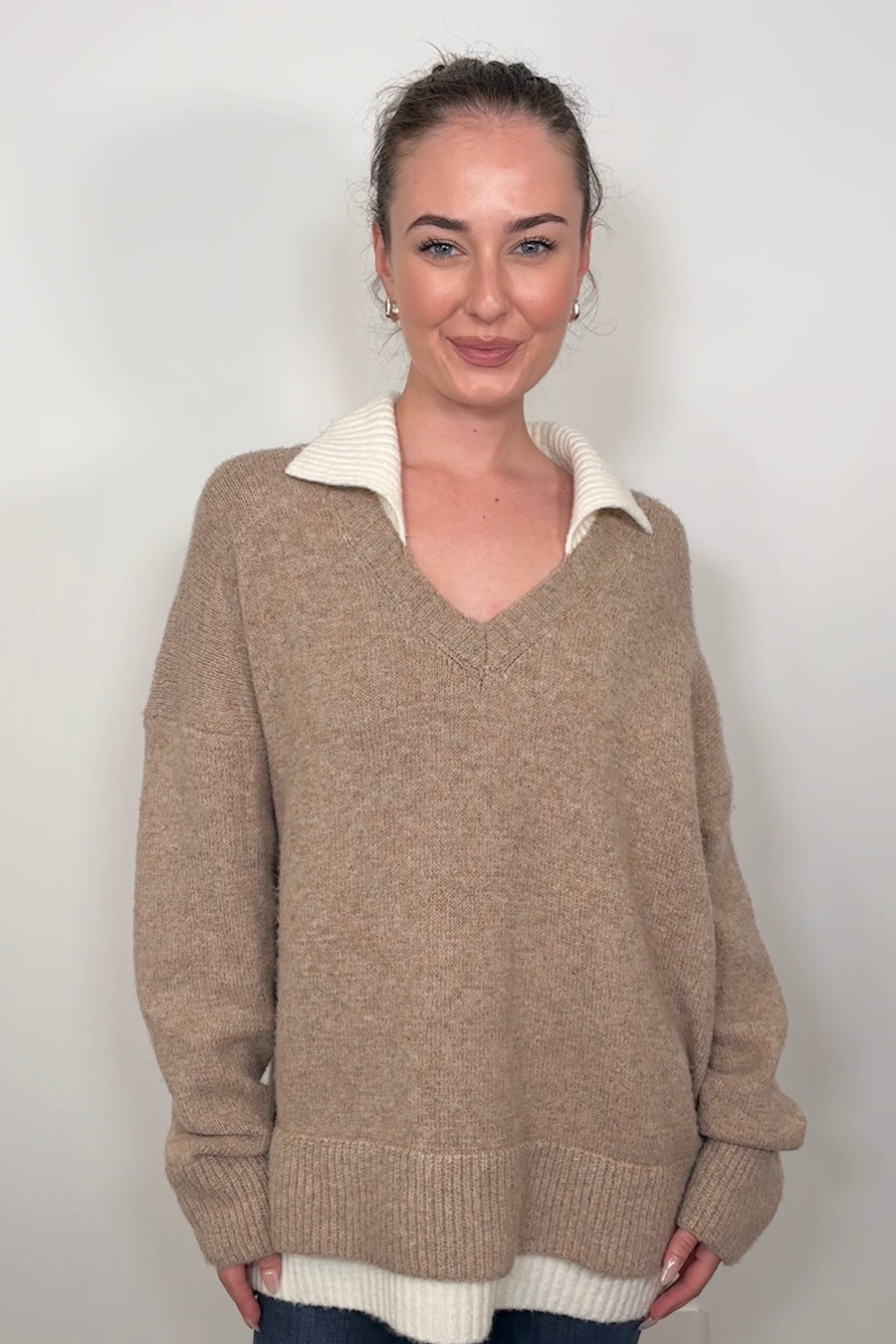 Front view of woman wearing a cool beige white- collar sweater