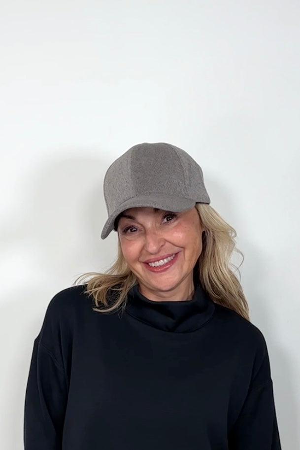 Front view of a woman wearing an light gray coloured baseball felt hat