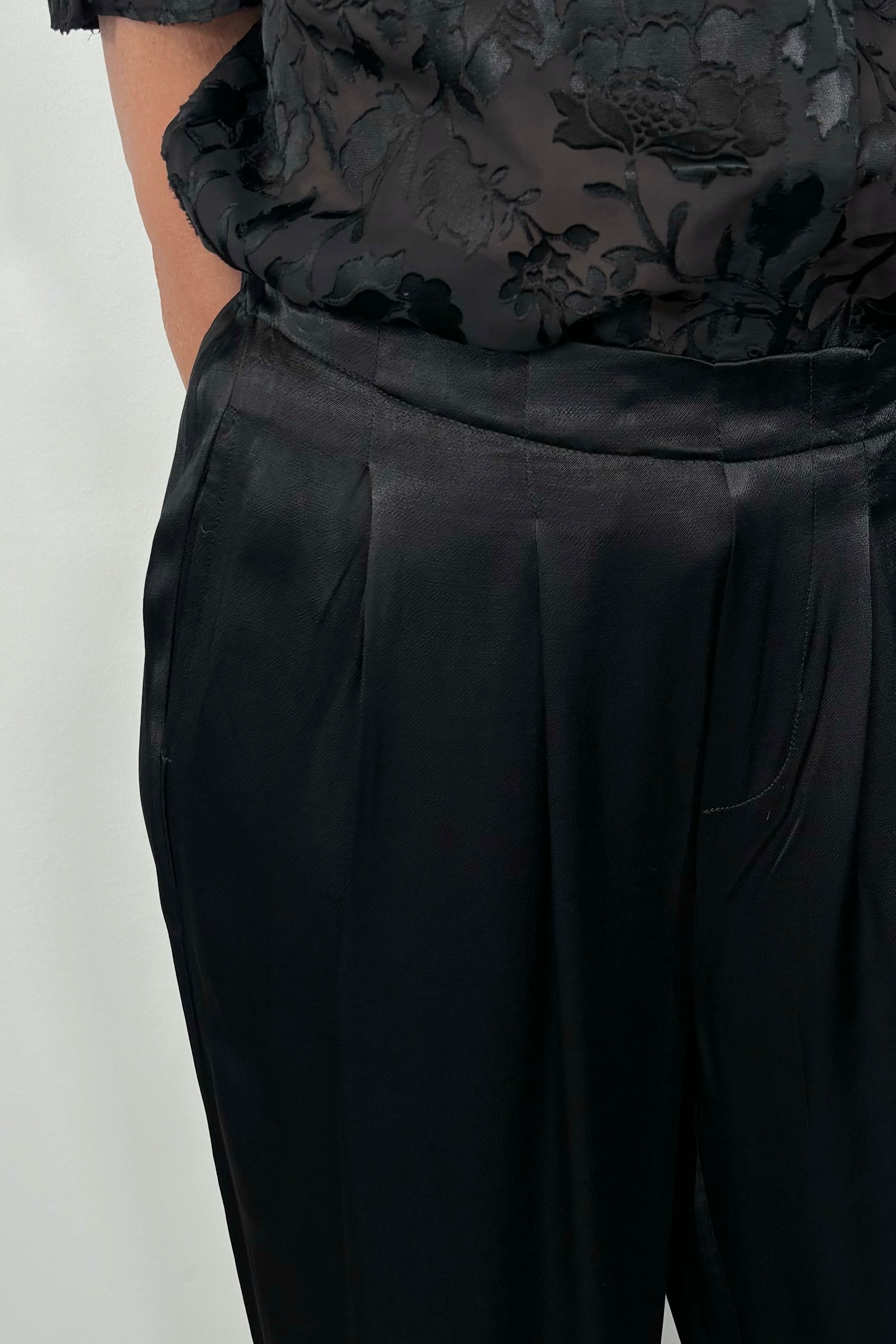 close-up of black satin pants