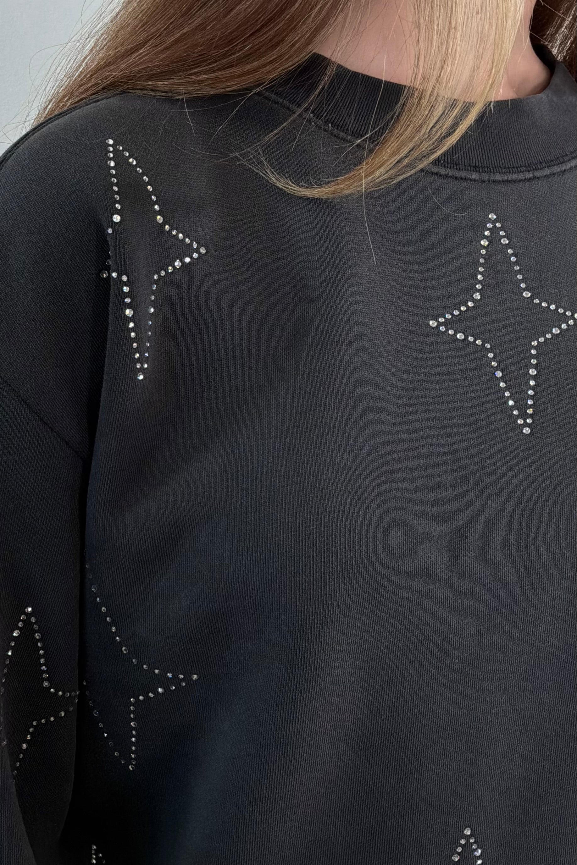 close-up of a gray sweatshirt with stud stars