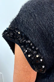 close-up of a black fuzzy cap sleeve embellished sweater