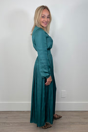 Side view of woman wearing a green maxi long sleeve silk dress