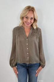 Woman wearing an olive green button up blouse 
