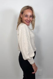 Side view of woman wearing a blouson cuffed sleeve beige top
