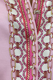 Close up of woman wearing a pink silk button down with rouching on the sleeves tucked in