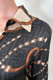 Close up view of the collar of a printed button up shirt