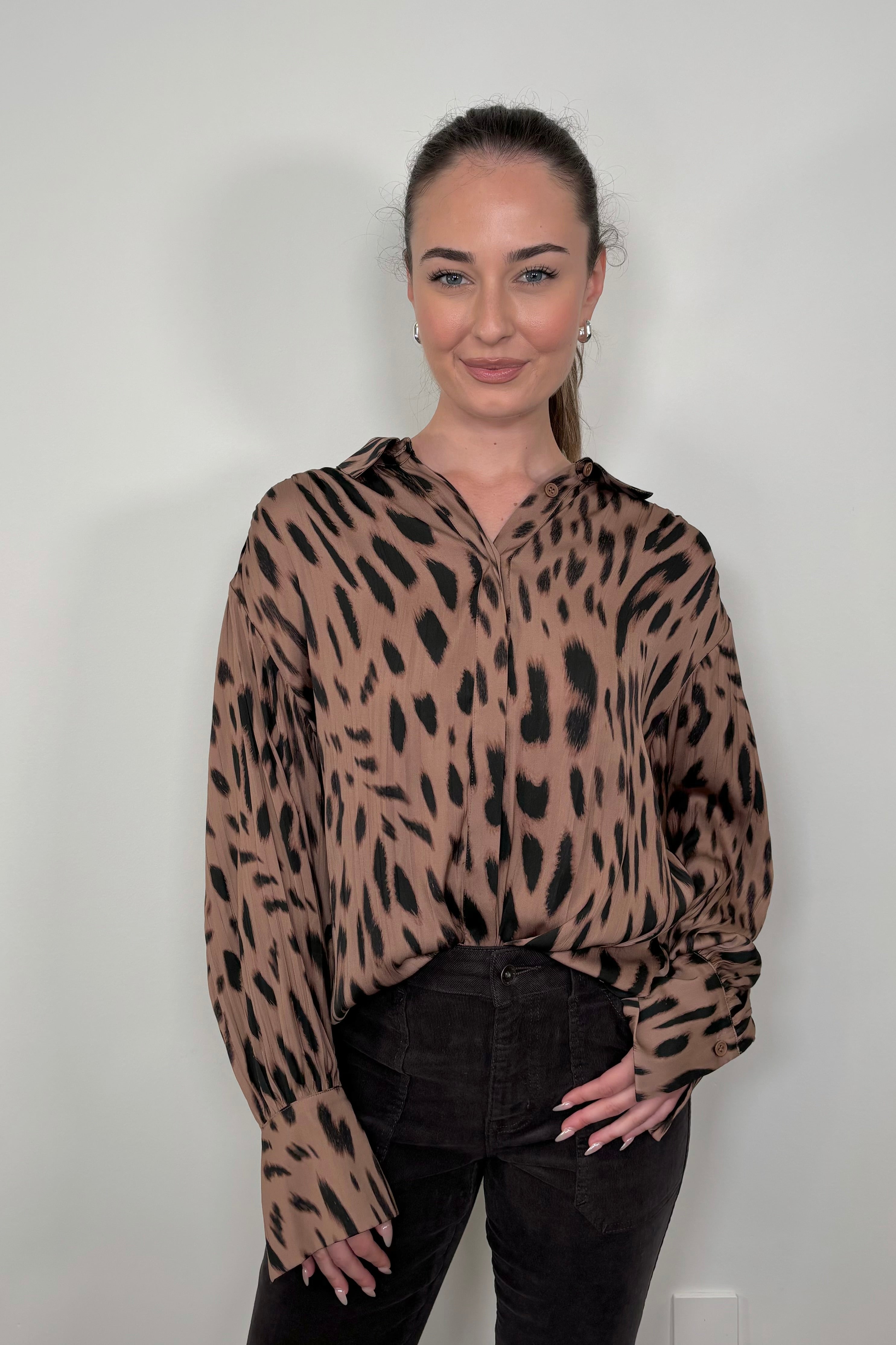 Front view of woman wearing a brown printed blouse 