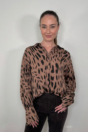 Front view of woman wearing a brown printed blouse 