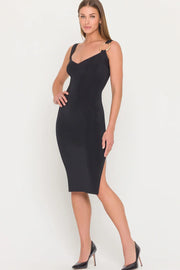 Woman wearing a black dress with a gold metal detail on the strap