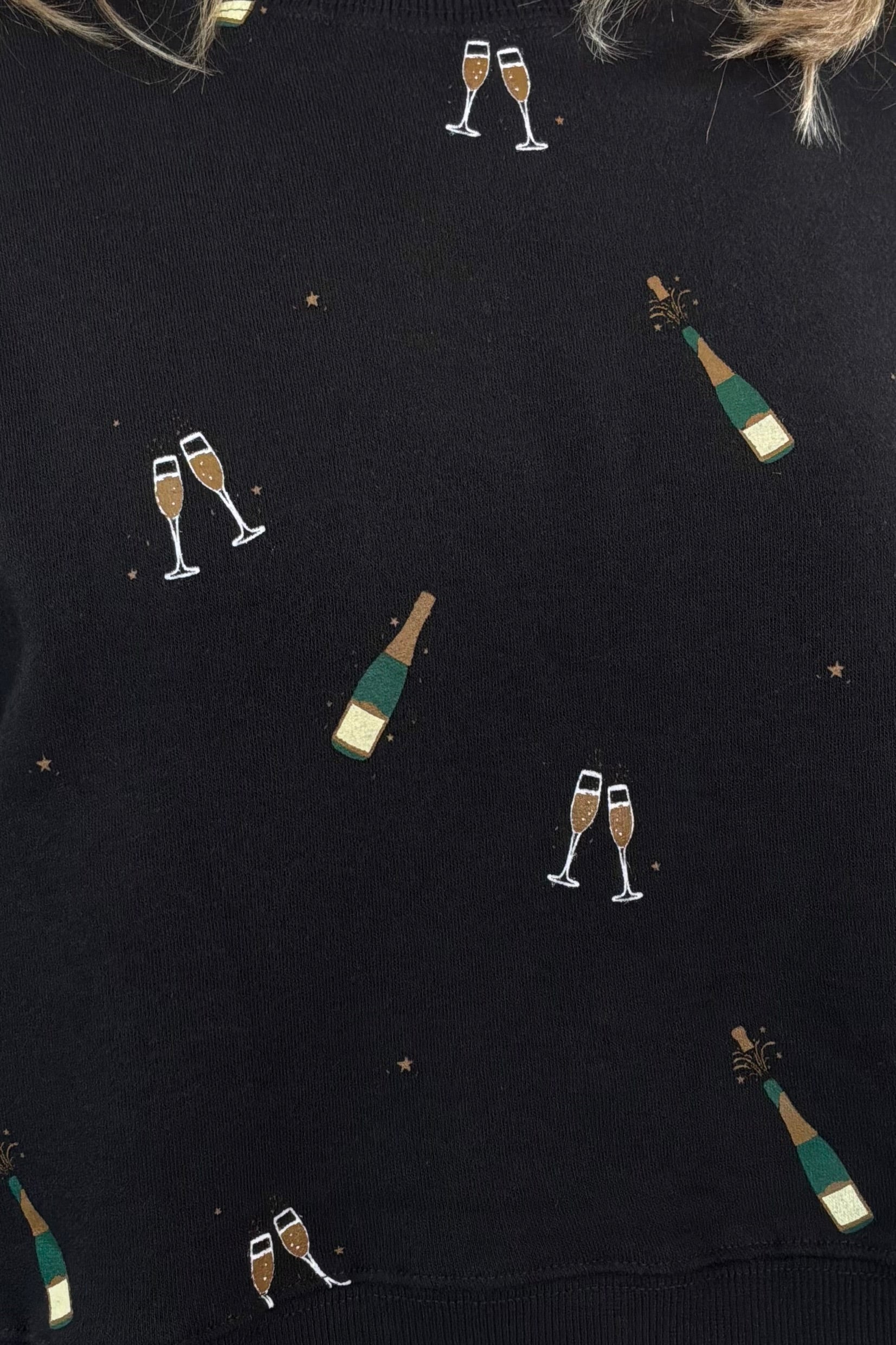 Close-up of black sweatshirt with champagne bottle print 