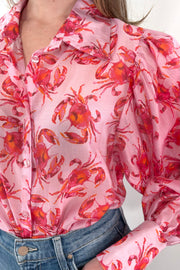Close-up of women wearing pink long sleeve blouse with crab, print all over