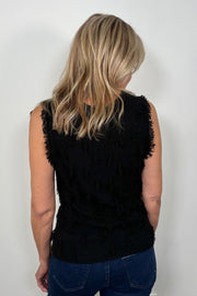 Back view of a woman wearing a black tank top with fine gauge fringes 