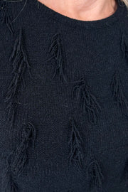 Close up of the beck of a black tank top with fine gauge fringes 