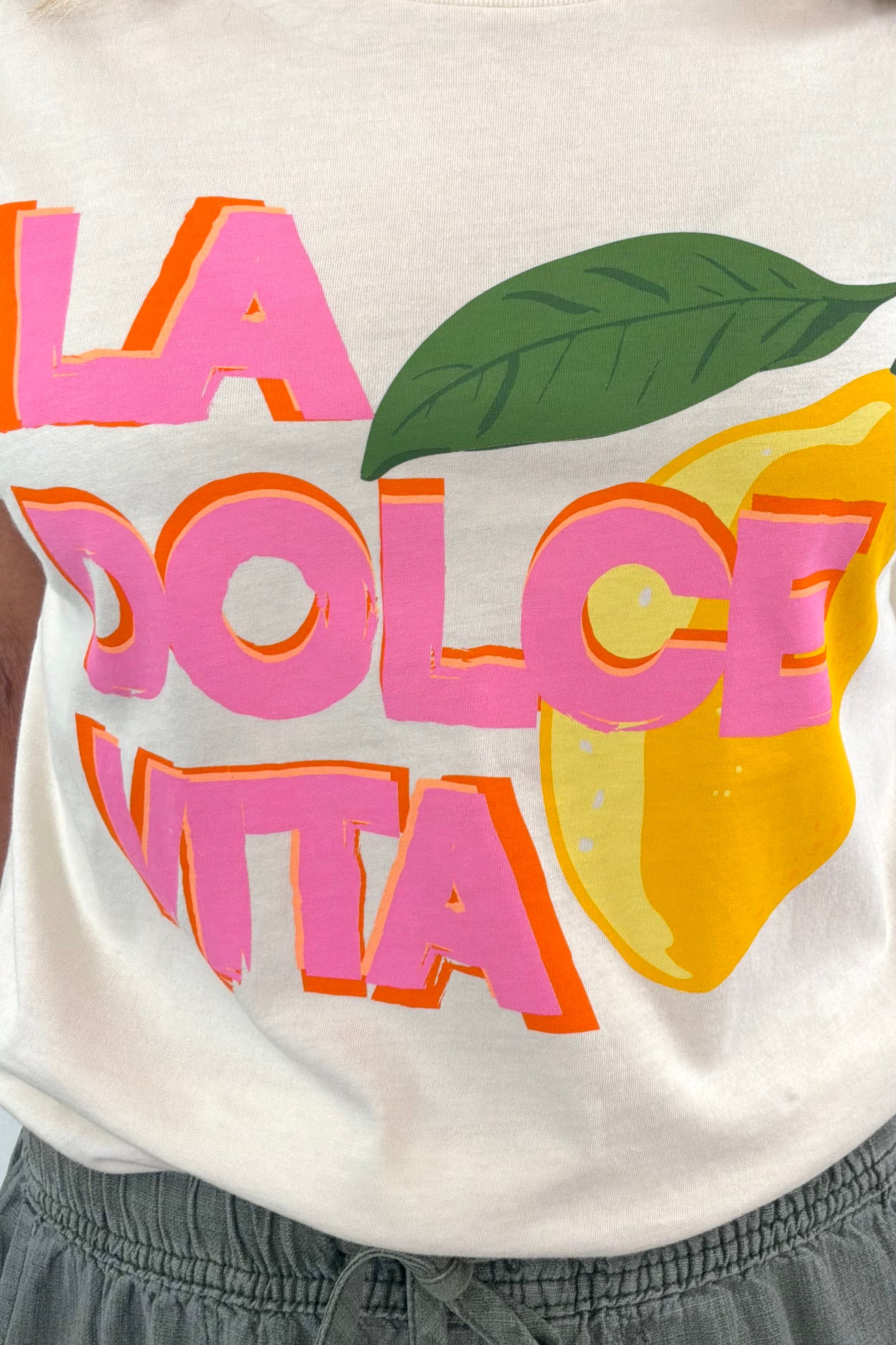 Close up of Woman wearing while T shirt with ” la dolce vita” details