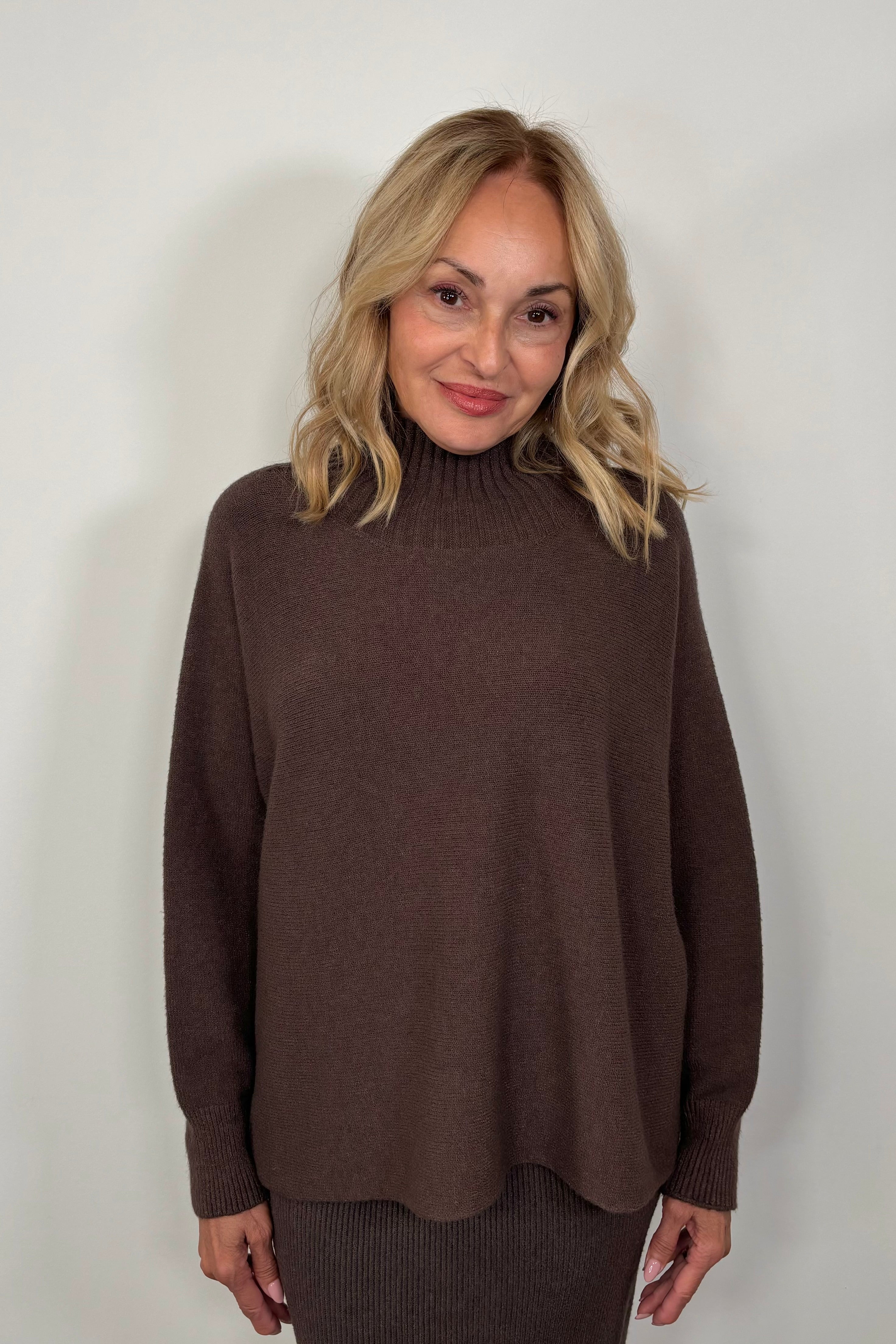 woman wearing a brown oversized mock neck sweater