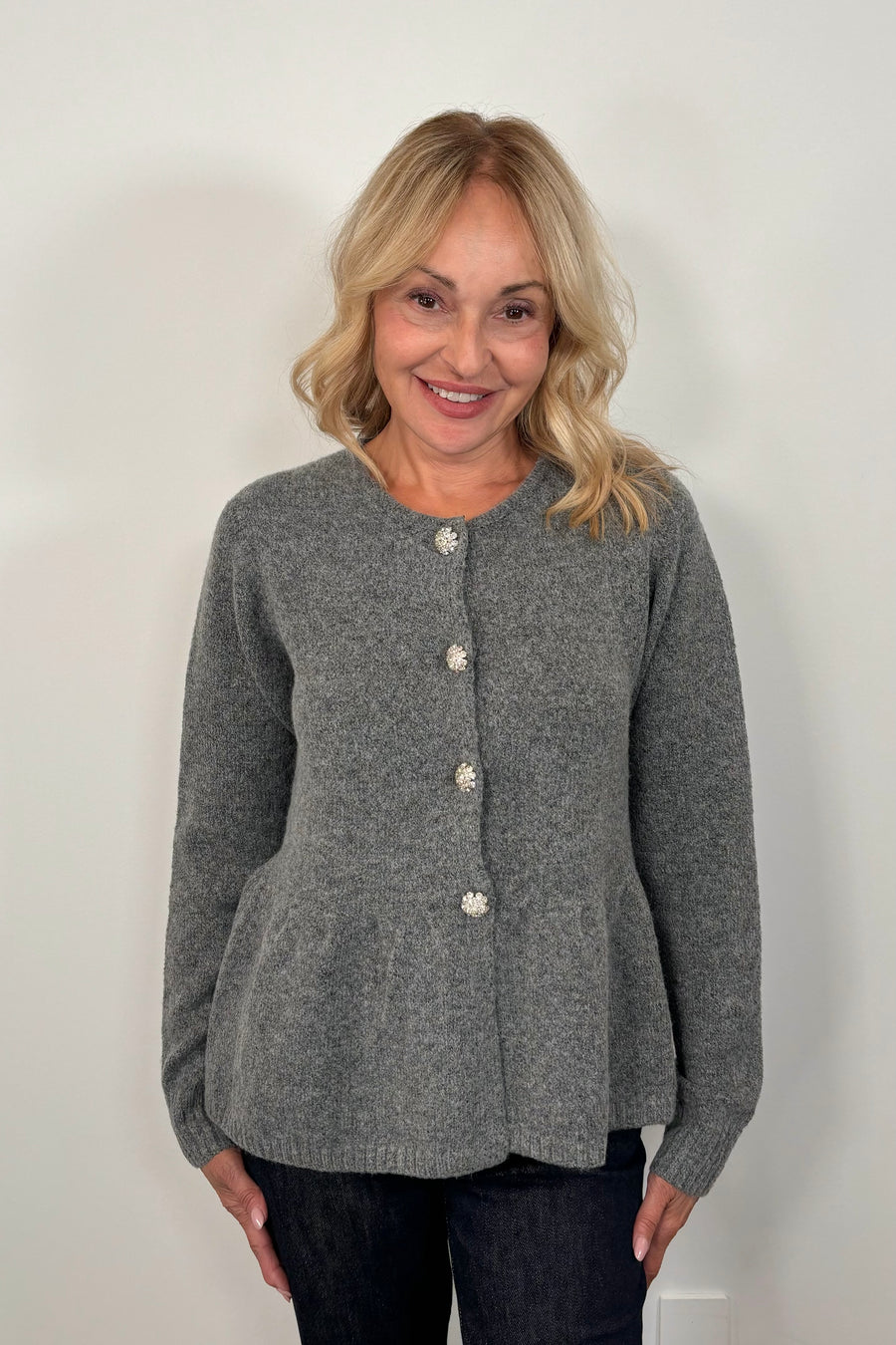 woman wearing a gray  peplum cardigan