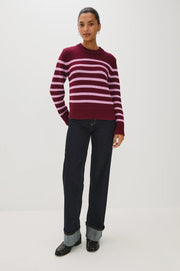 Woman wearing a maroon and pink striped sweater 